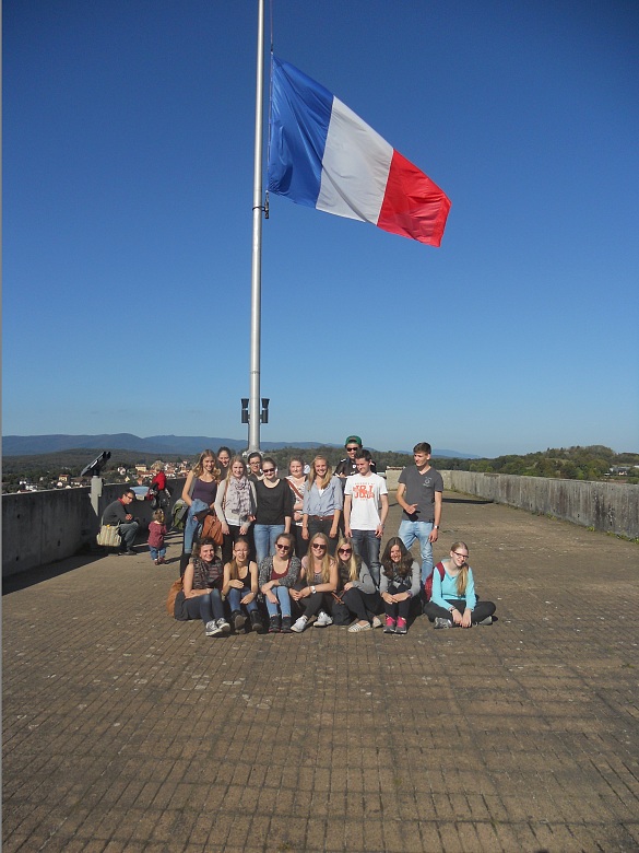 Gruppenfoto der Teilnehmer nebene einer französischen Flagge