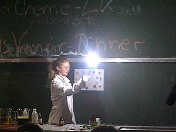 Foto einer Schülerin im Hörsaal mit einer brennenden Fakel in der Hand