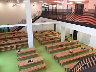 Ein Foto der Mensa mit Tischen und Bänken.