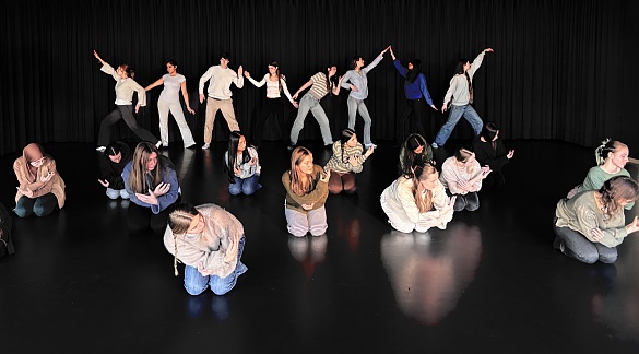 Bild von Schülern in einem schwarzen Raum die tanzende Bewegungen machen